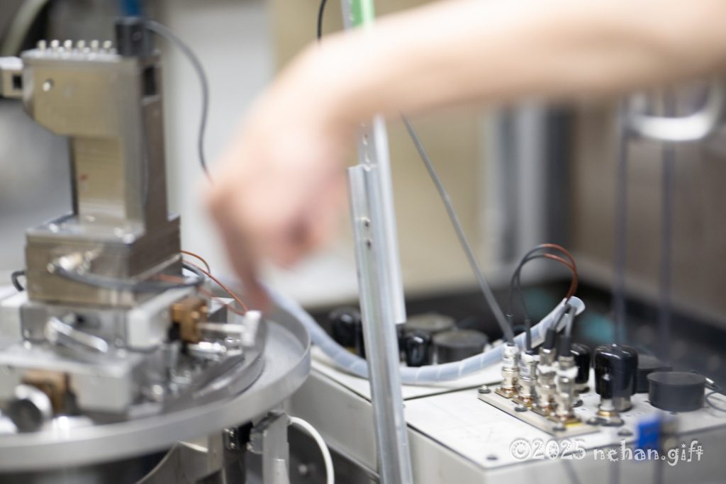 事業内容に関連する精密機器の操作風景。研究または実験の様子を示す。