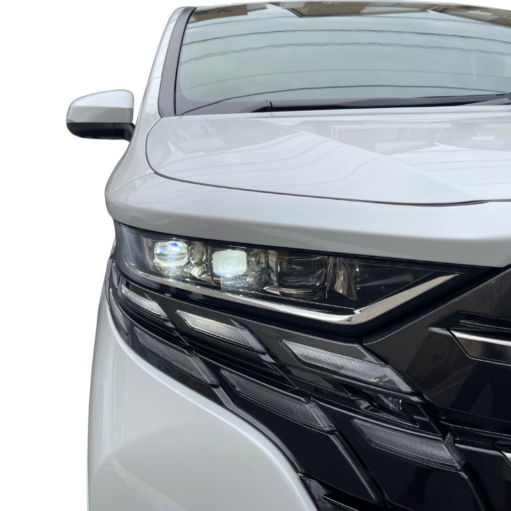 白い車のヘッドライト部分のクローズアップ。「採用情報」に関連する車のイメージ。